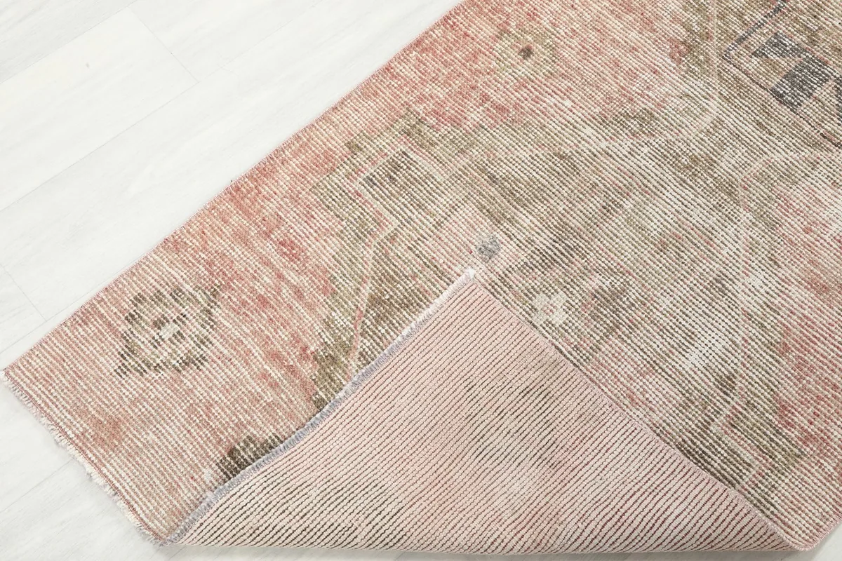 Corner of the rug folded to reveal the cotton foundation and the reverse side of the hand-knotting.