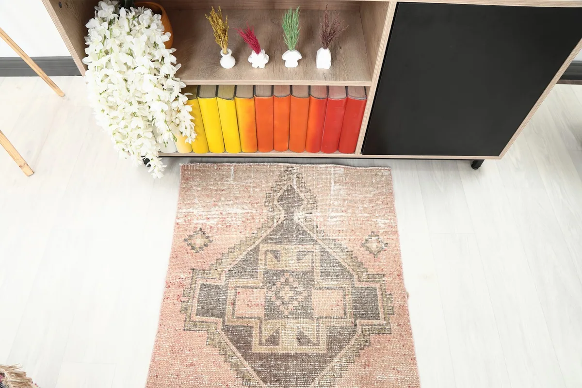 Overhead detail of the central geometric medallion and surrounding rose field of the runner rug.