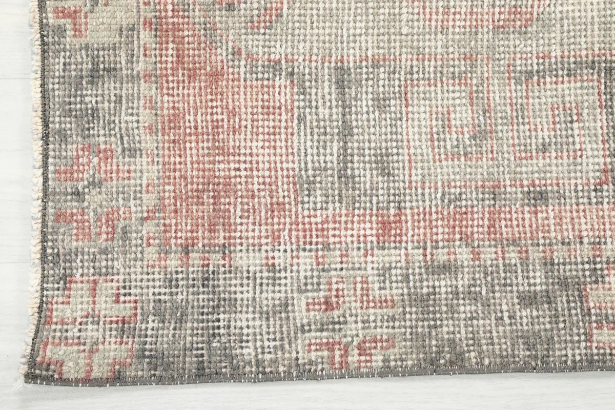 Corner detail of the runner rug, highlighting the distressed texture and color variations.