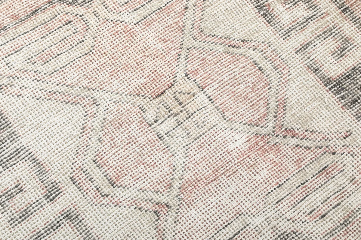 Tight close-up showing the low wool pile and hand-knotted texture of the rug.