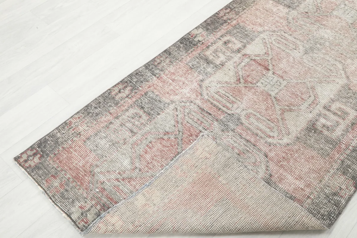 View of the back of the runner rug, showing the cotton foundation and knotting.
