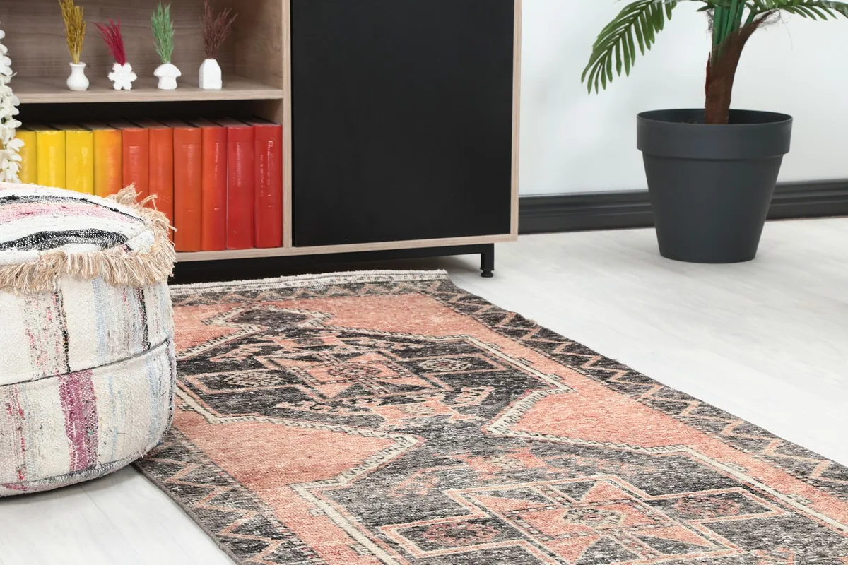 Close-up of the runner's pattern next to a cabinet and pouf in a home setting