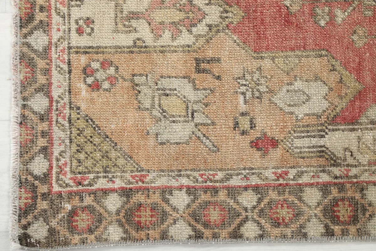 Corner detail of the rug's border, showcasing intricate patterns and color variations