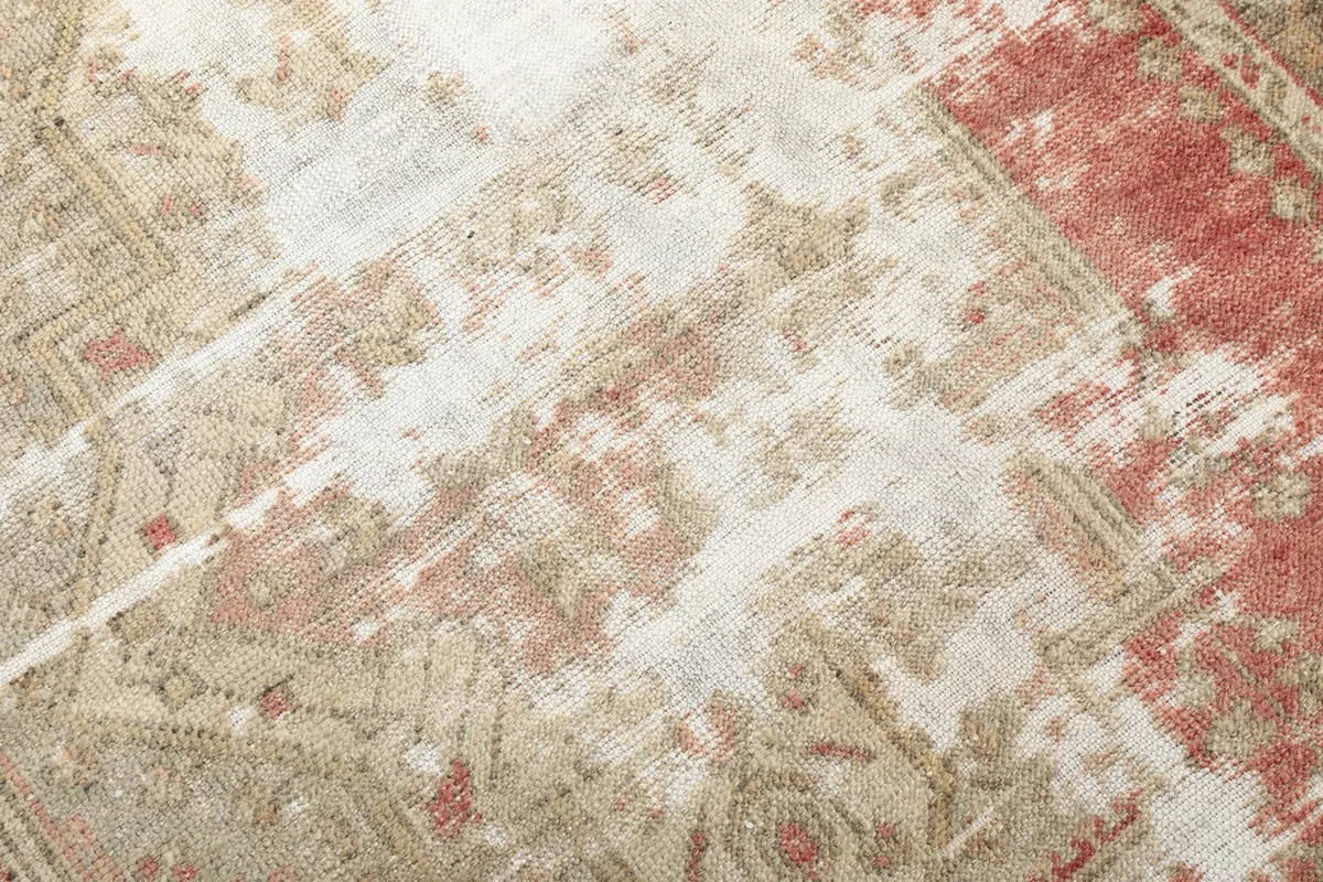 Close-up of the low wool pile, showing texture and the distressed areas of the rug