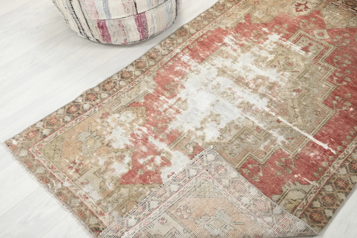 View of the rug with a corner folded back, showing the cotton foundation and reverse side