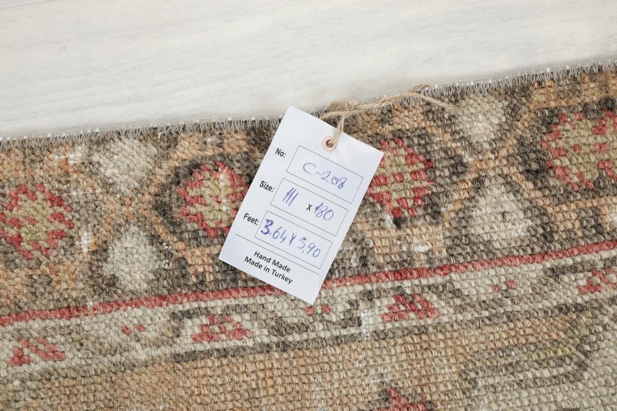 Tag on the rug showing its size in feet and centimeters, and 'Hand Made in Turkey'