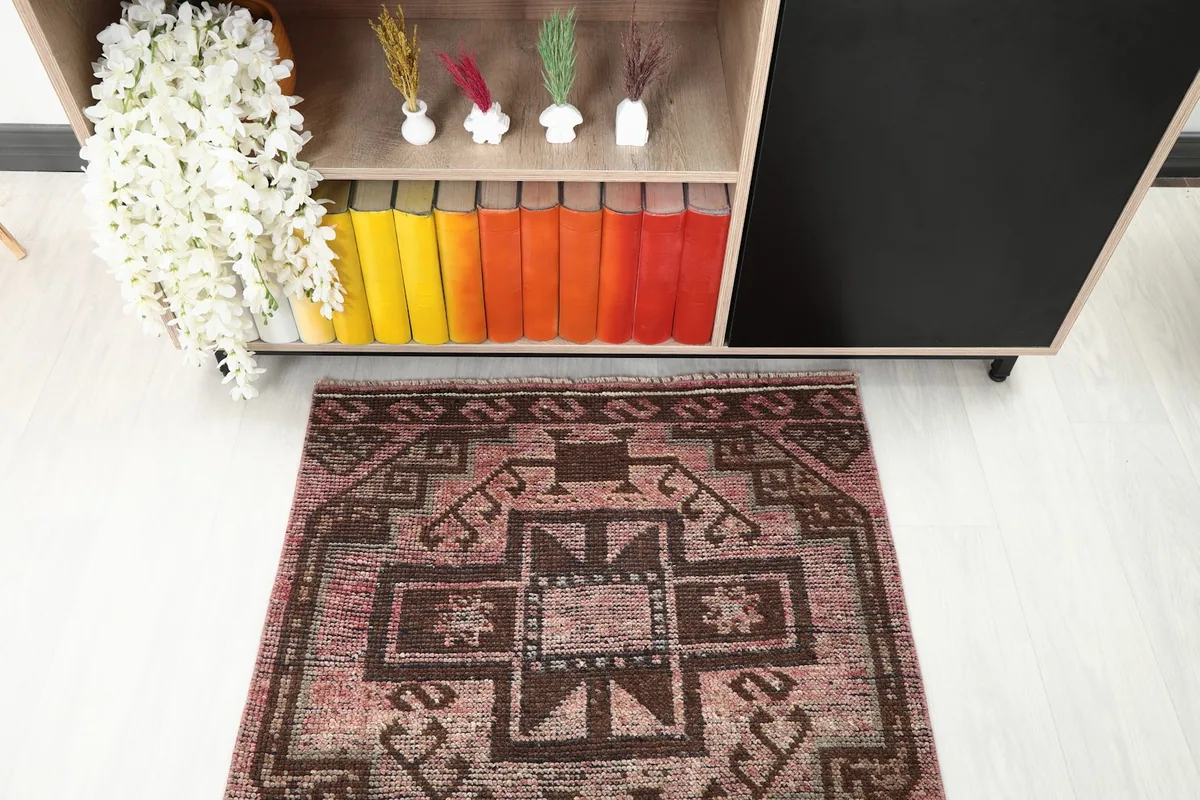 Detail of one end of the runner rug's pattern in a room setting near a bookshelf