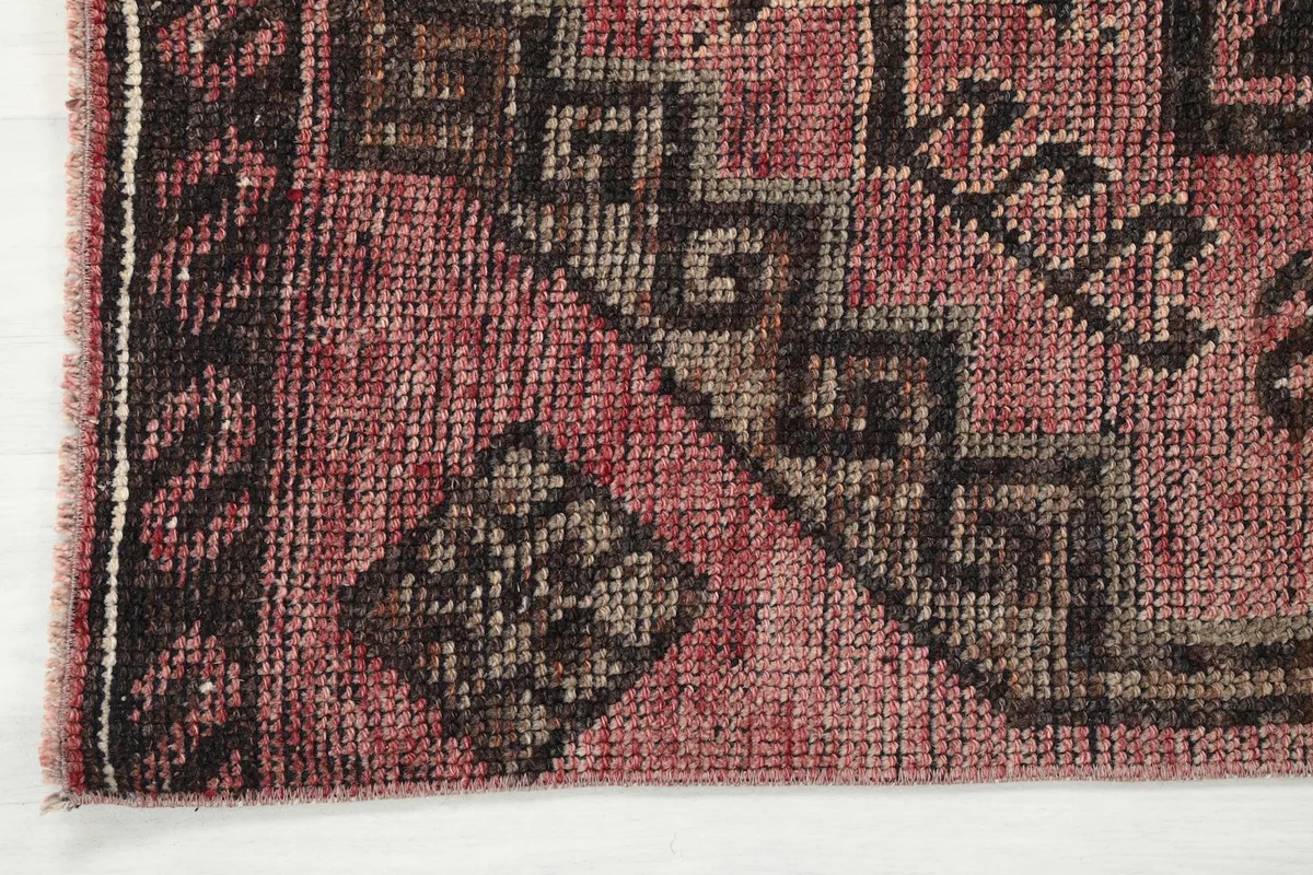 Corner detail of the runner rug, showing the border design and texture of the pile
