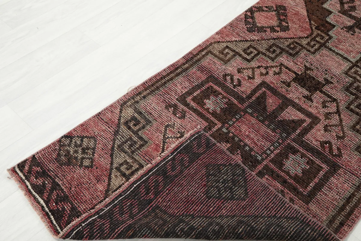 Folded corner of the runner rug, revealing the reverse side and knotting structure