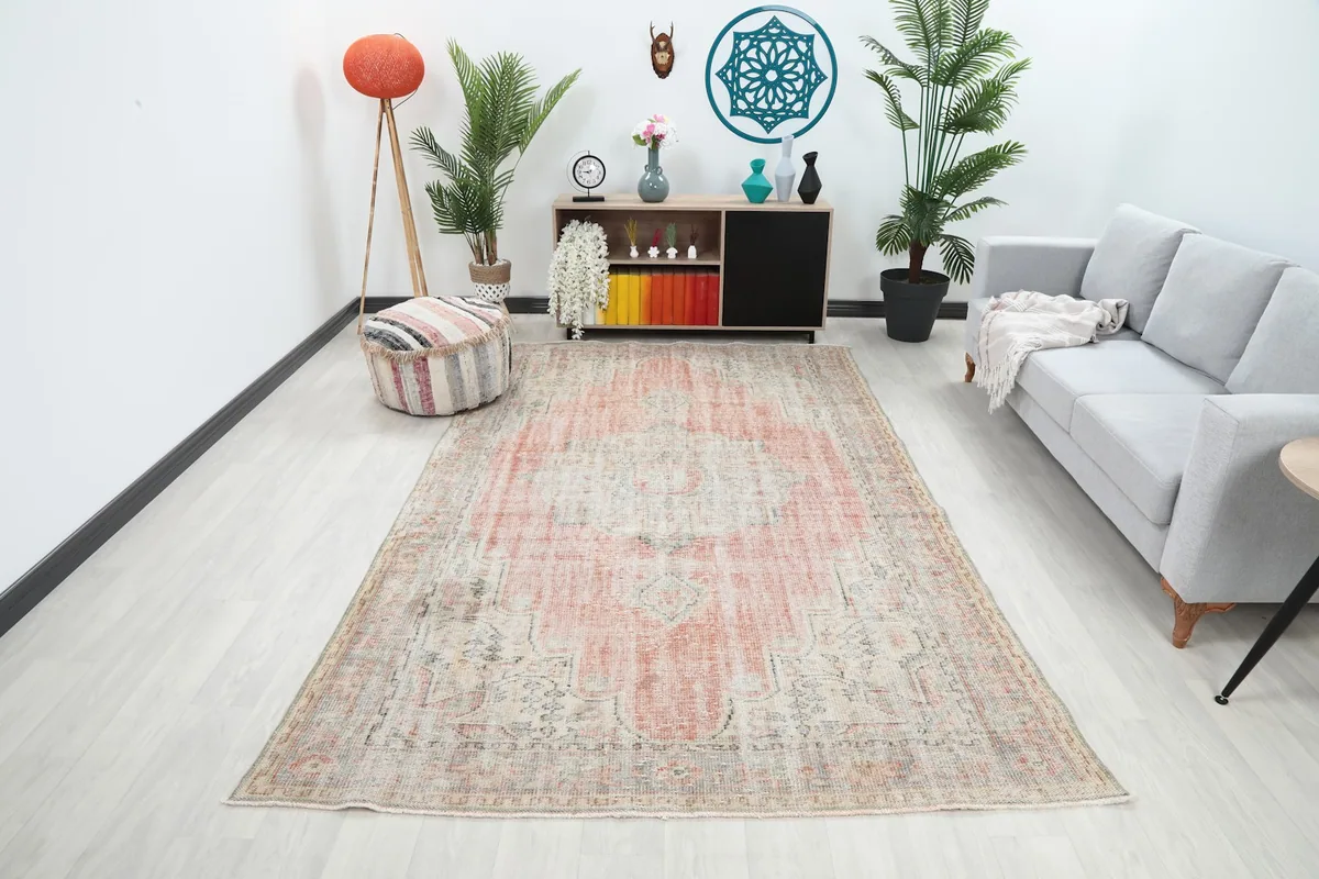 Vintage rug displayed in a bright living room setting with a gray sofa and modern decor