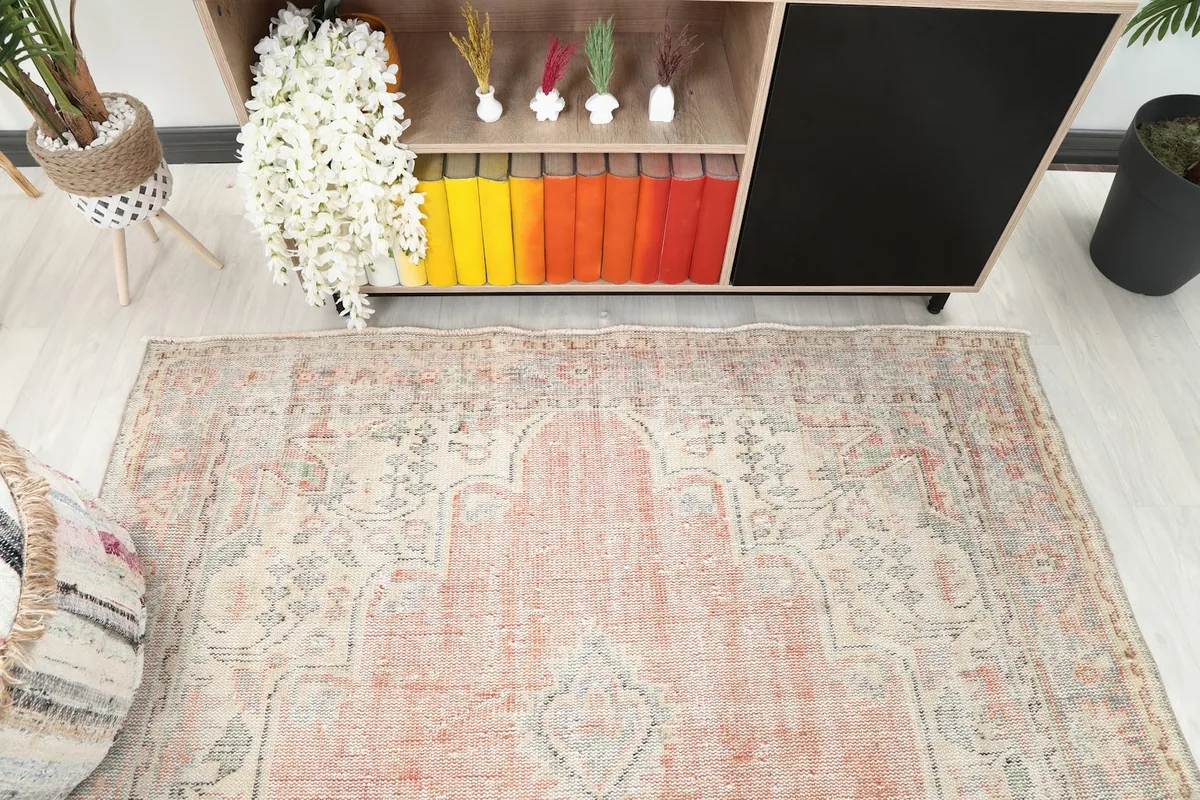 Detail of the vintage rug's field and border patterns in a room setting, looking down from above