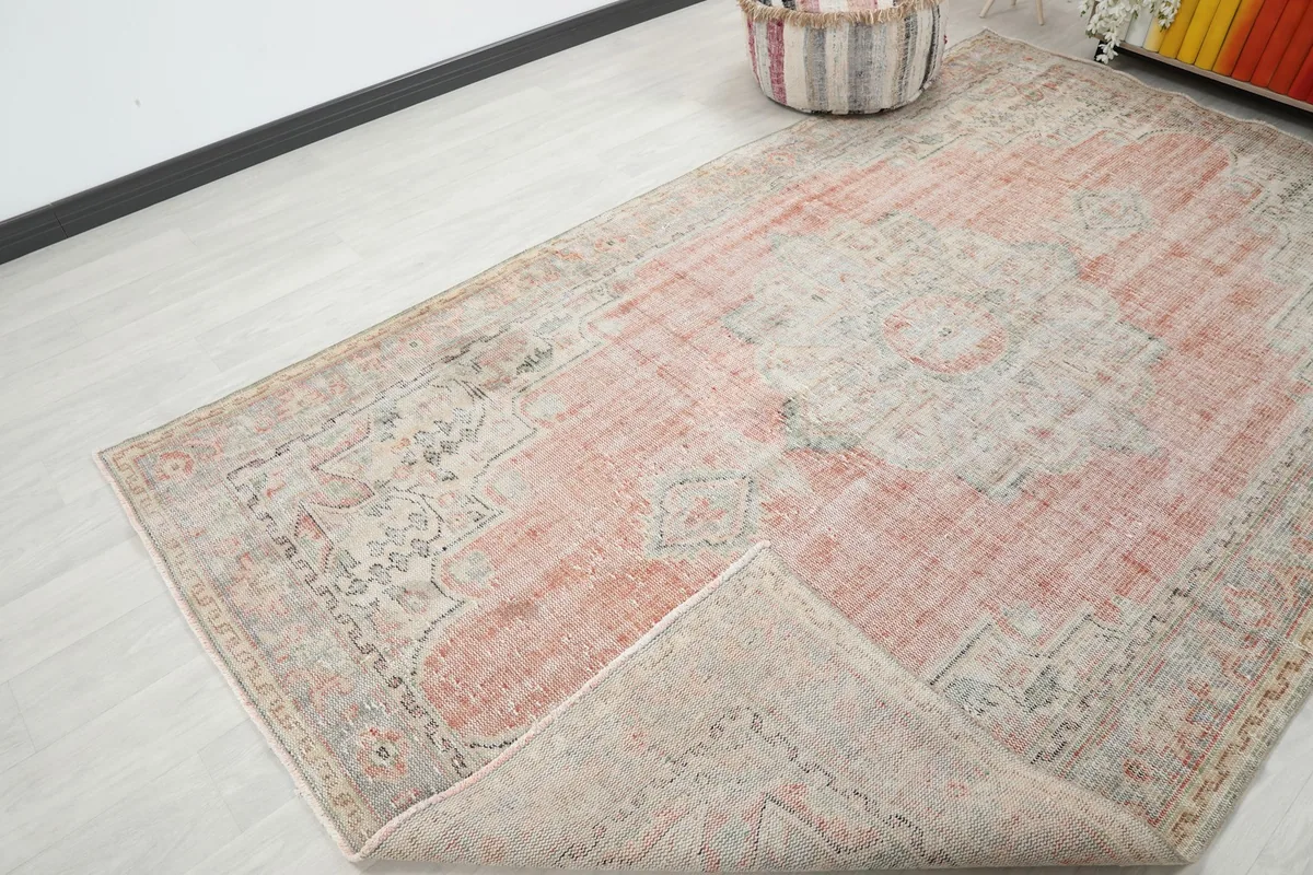 Corner of the vintage rug folded back, revealing the cotton foundation and reverse side