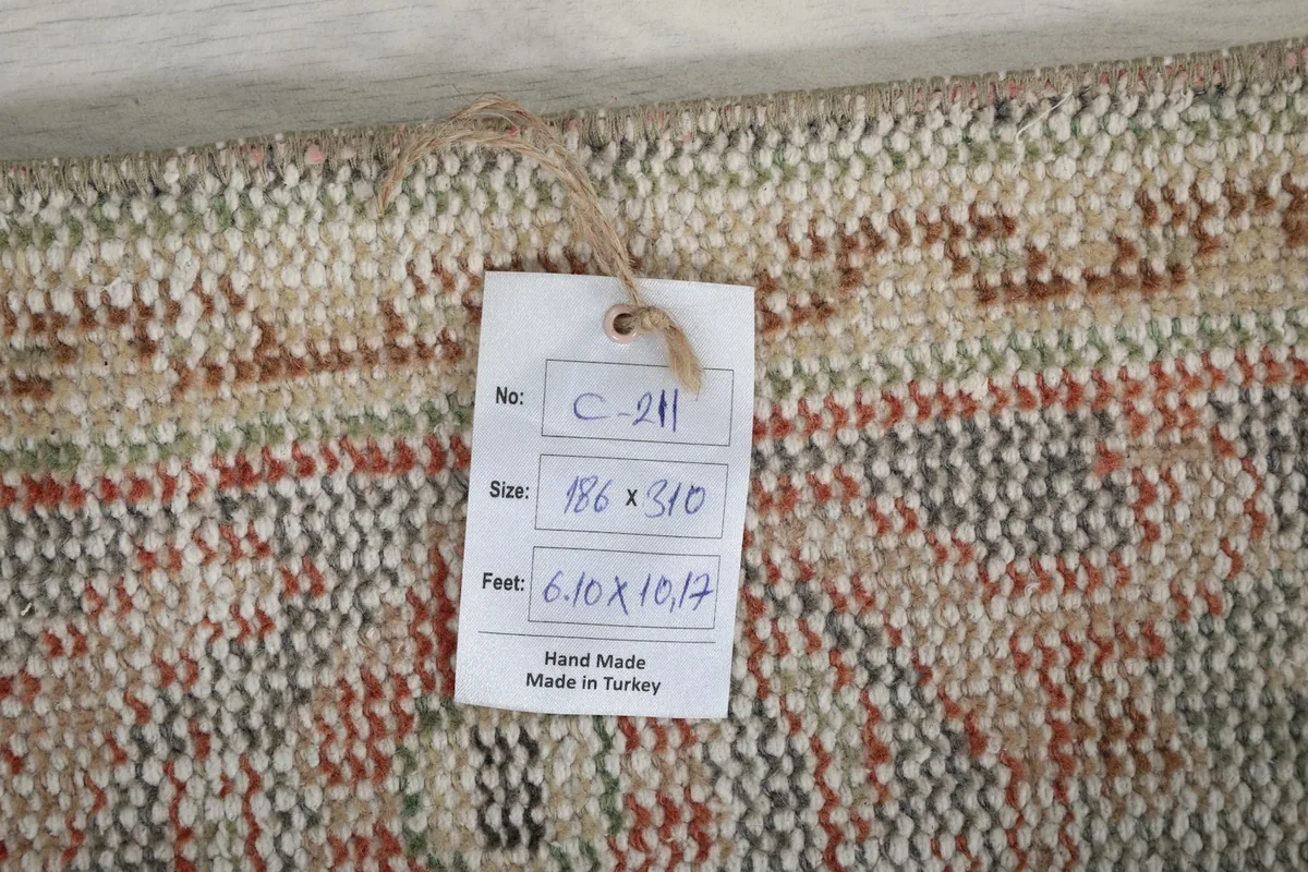 Tag showing the rug's dimensions in centimeters and feet, confirming it is handmade in Turkey