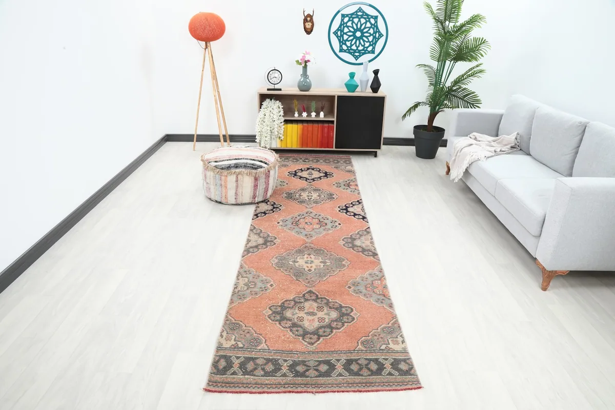 Vintage rust runner rug displayed in a modern living room setting, extending from foreground to background.