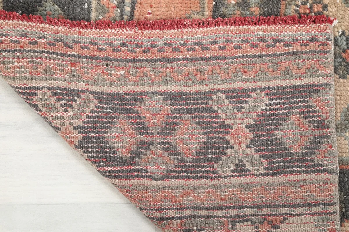 Detailed view of the rug's backside, showing the tight hand-knotted cotton foundation and wool pile.