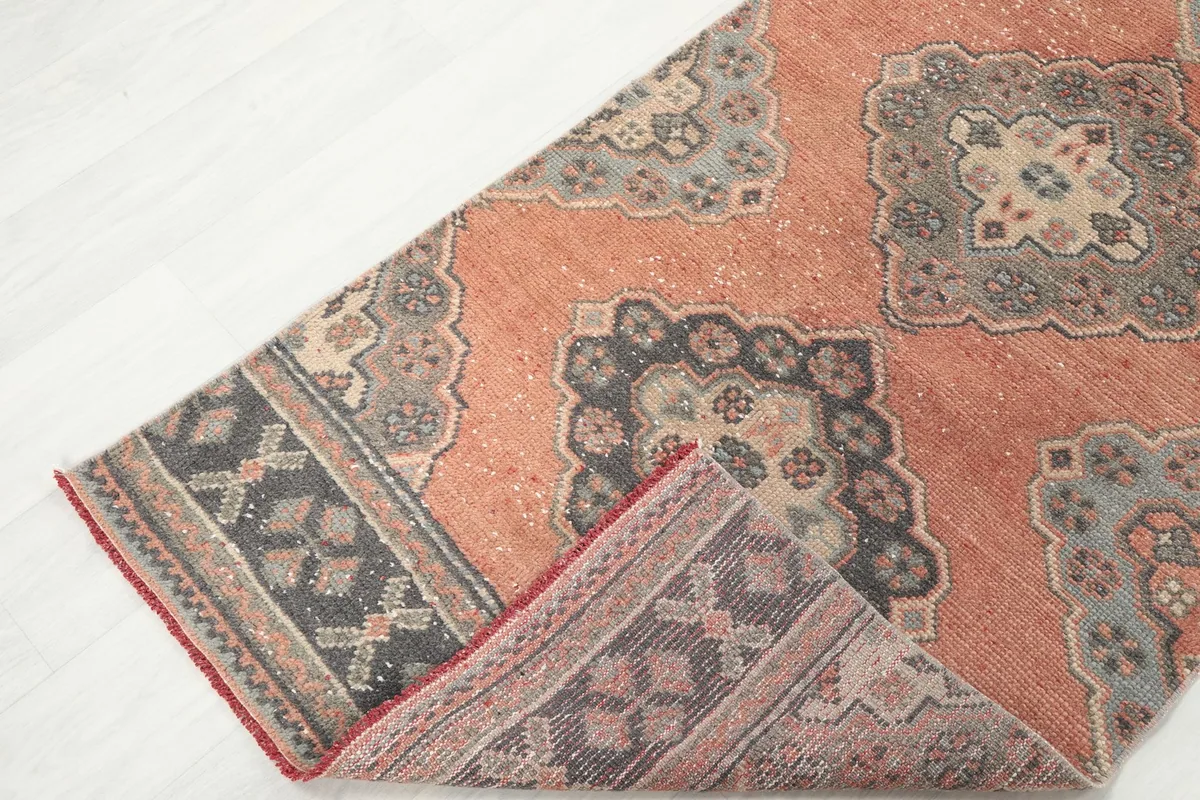 View of the rug folded to show the backside of the border and the quality of the hand-knotted construction.
