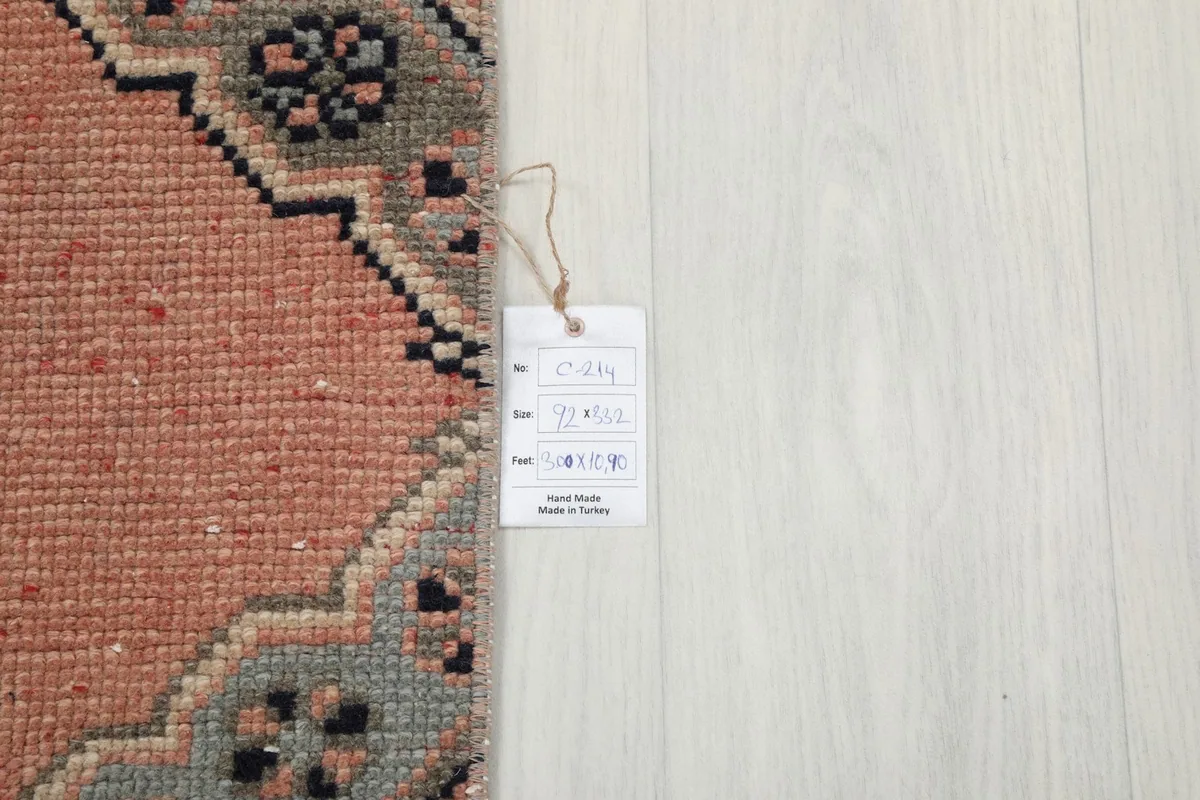 Corner of the rug with its product tag, showing the hand-made in Turkey label on a light wood floor.