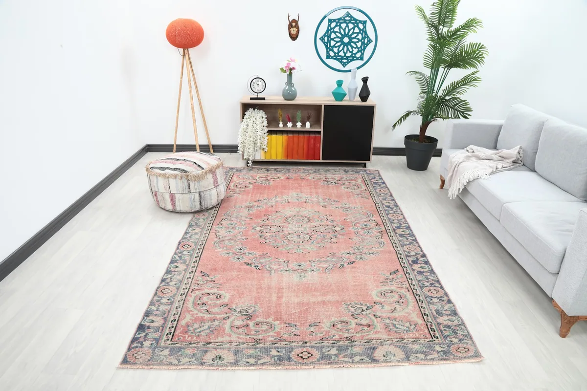 Vintage Anatolian rug in a modern living room setting with a gray sofa and wooden furniture.