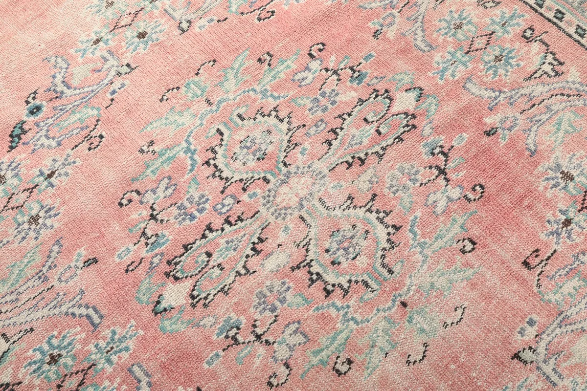 Close-up on the central medallion's intricate floral and geometric details in blue, black, and rose.