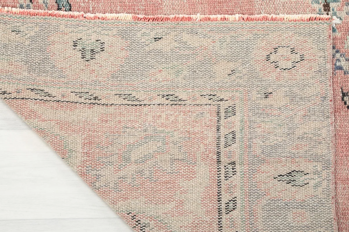 Detailed view of the rug's cotton foundation and the reverse side of the hand-knotted wool pile.