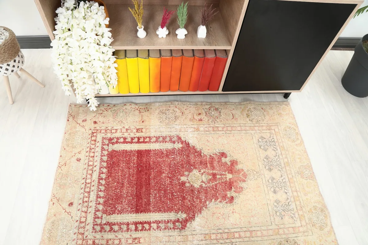Close overhead view highlighting the mihrab design and color variations of the vintage rug.