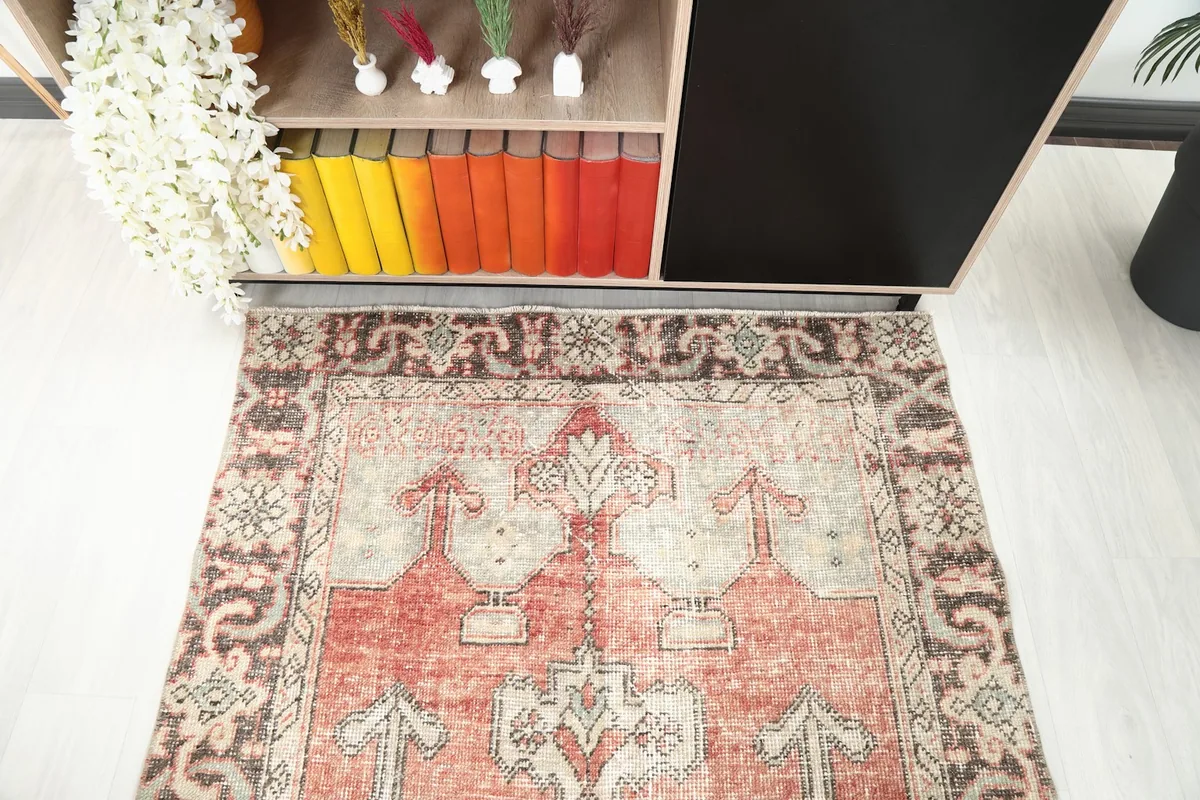 Detail of the rug's top portion in the room, near a wooden shelf with colorful books