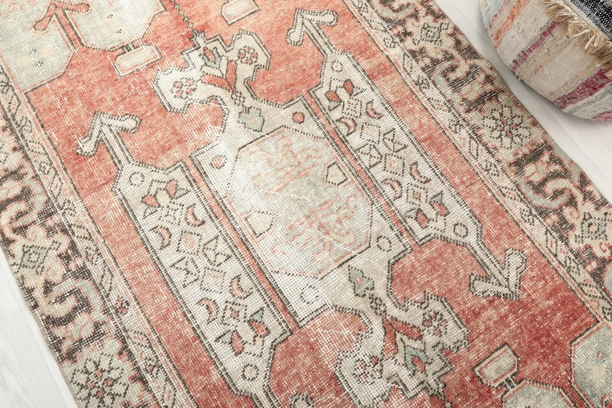 Detailed view of the central geometric medallion and tribal motifs in rust and beige