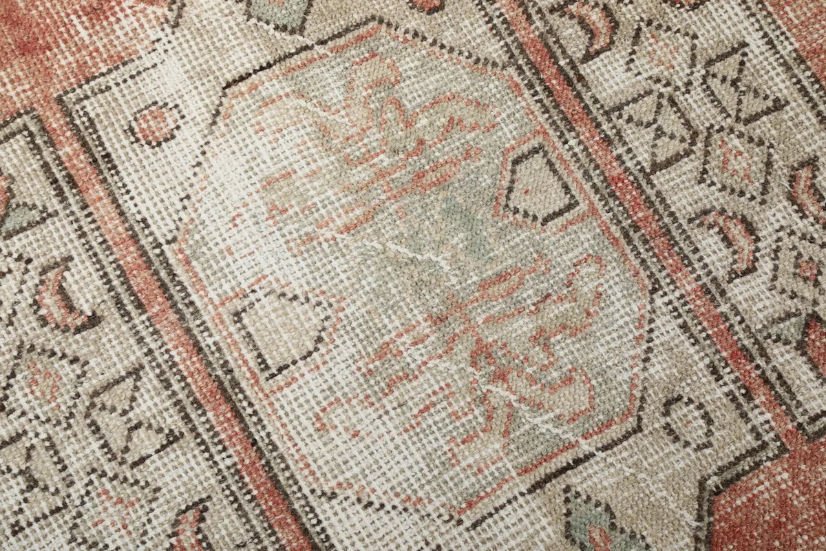 Close-up of the rug's low wool pile, showing the intricate knotting and color variations