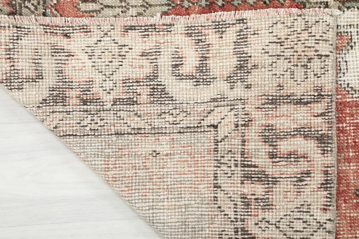 Underside view of the rug, showing the cotton foundation and the reverse of the knotting