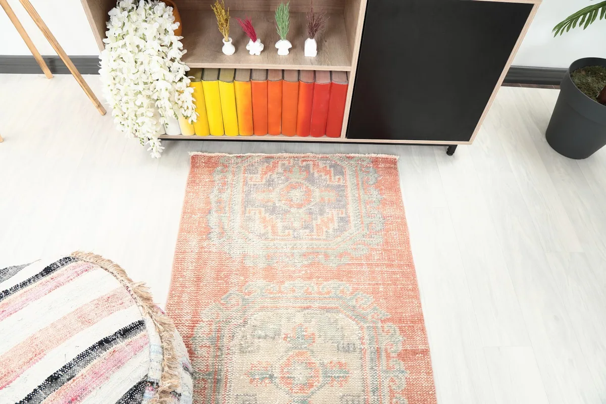 Angle view of the rust runner rug in a room, highlighting its geometric patterns