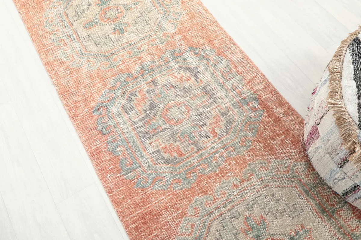 Close-up detail of the geometric medallion pattern on the rust runner rug