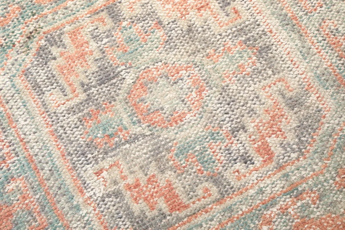 Detailed view of the hand-knotted wool pile and colors in a geometric motif