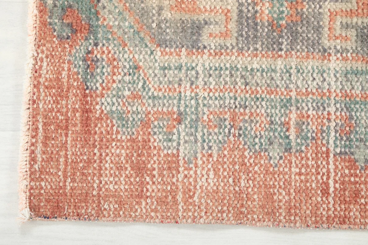 Close-up of the edge of the rust runner rug, showing the colors and texture