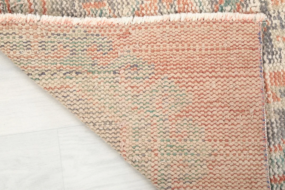 Underside view of the hand-knotted cotton foundation and wool knots of the runner