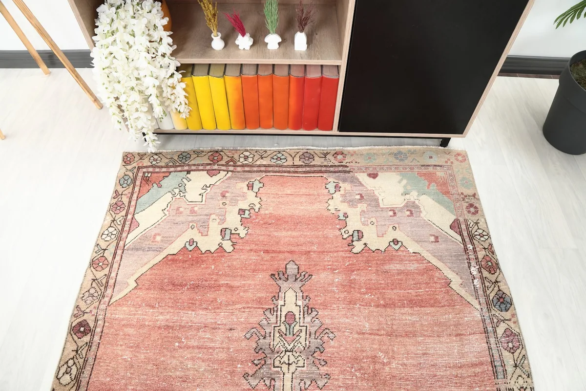 View from one end of the rose and beige rug, showing its placement relative to a console table.