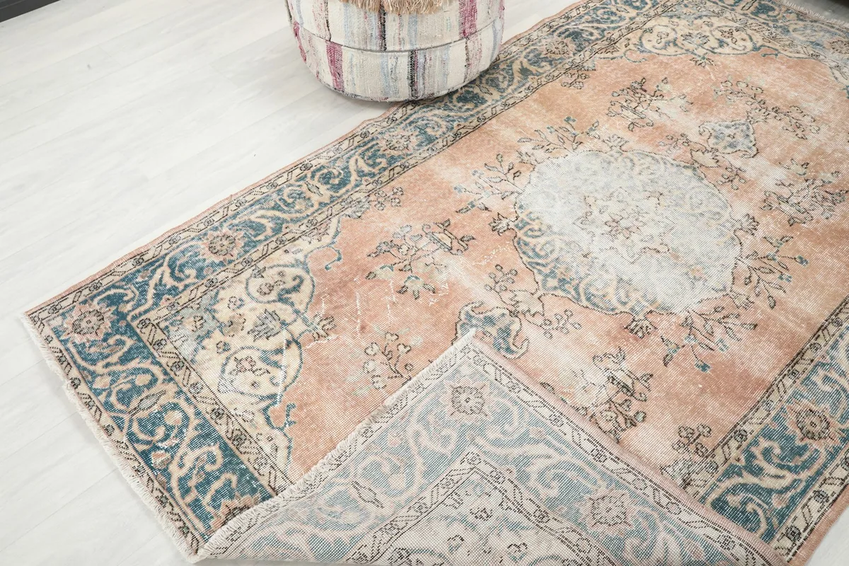 Corner of the rug folded back to reveal the back of the hand-knotted wool pile on cotton foundation.