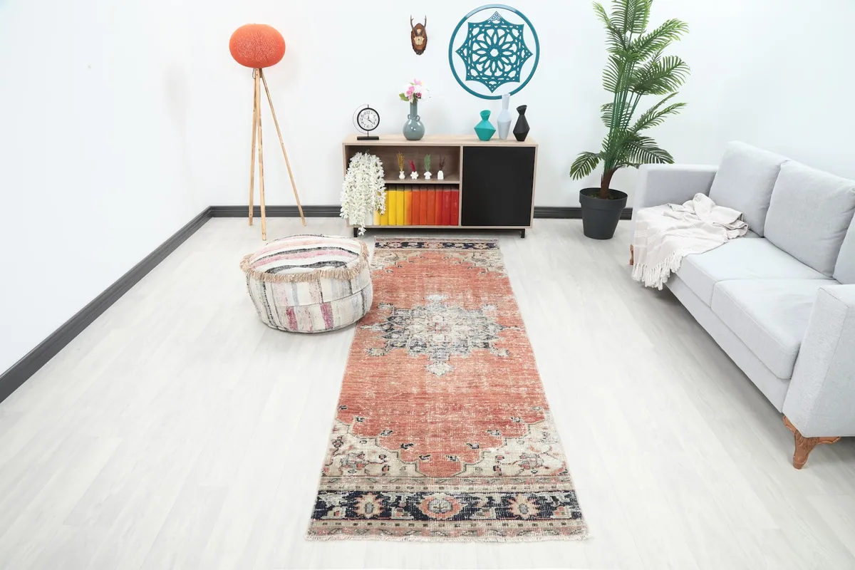 Vintage rust and navy runner rug in a modern living space with a grey sofa and wooden furniture
