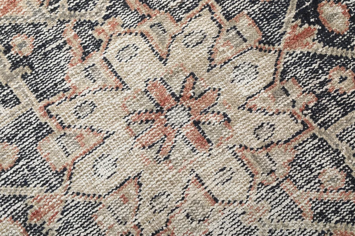 Extreme close-up showing the hand-knotted wool pile and intricate details of the rug's pattern