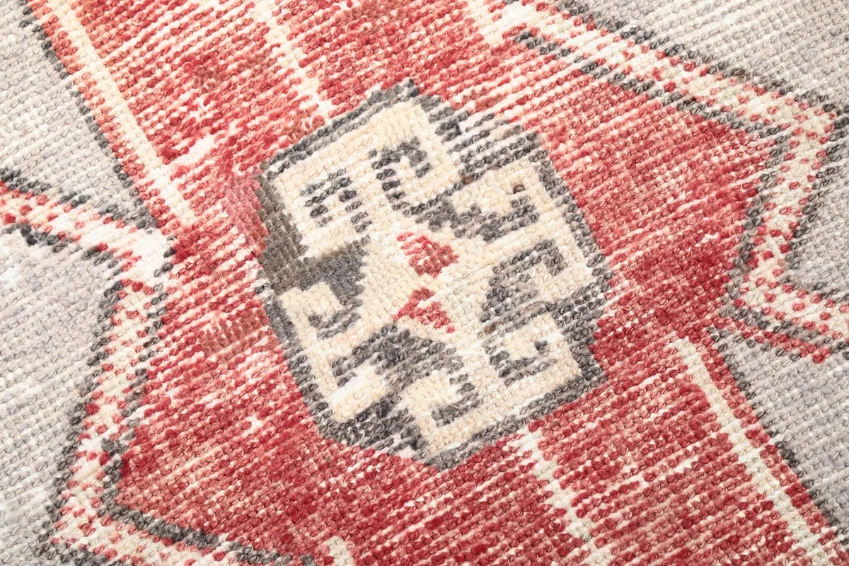 Close-up of the wool pile texture and faded red and gray colors