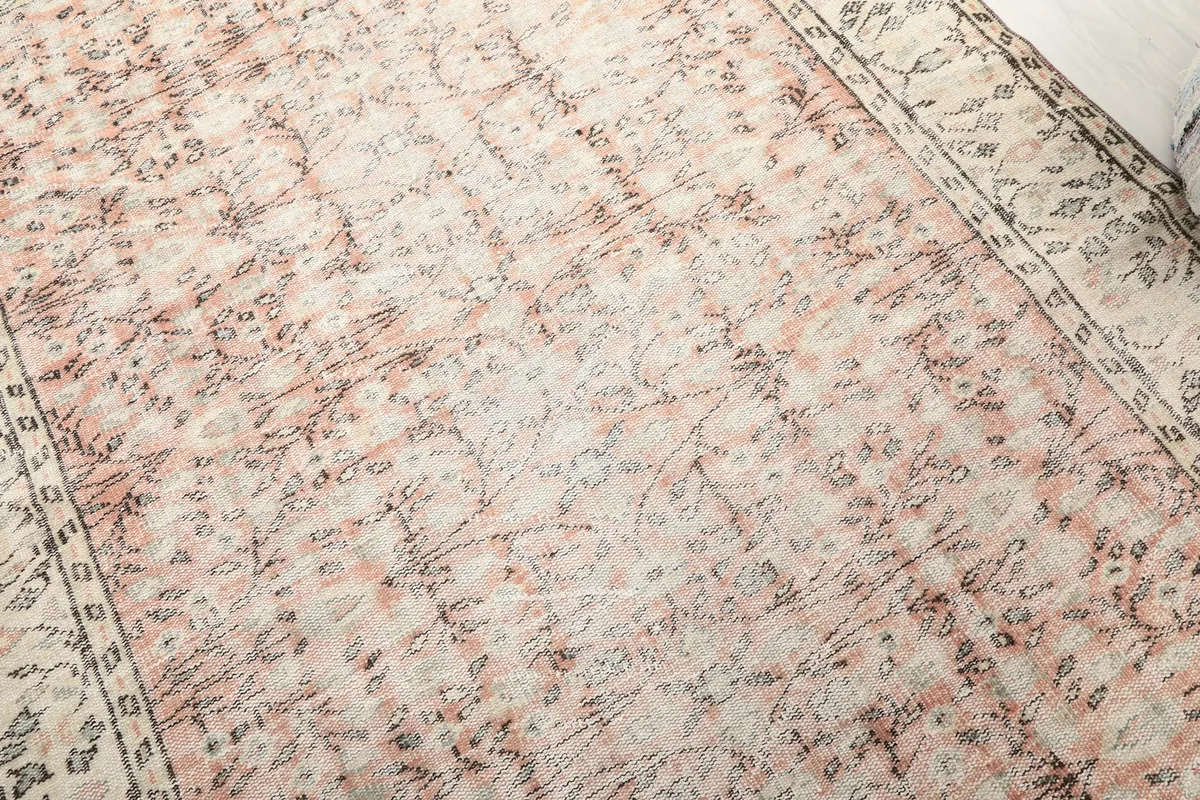 Detailed view of the faded rose field with subtle charcoal floral motifs