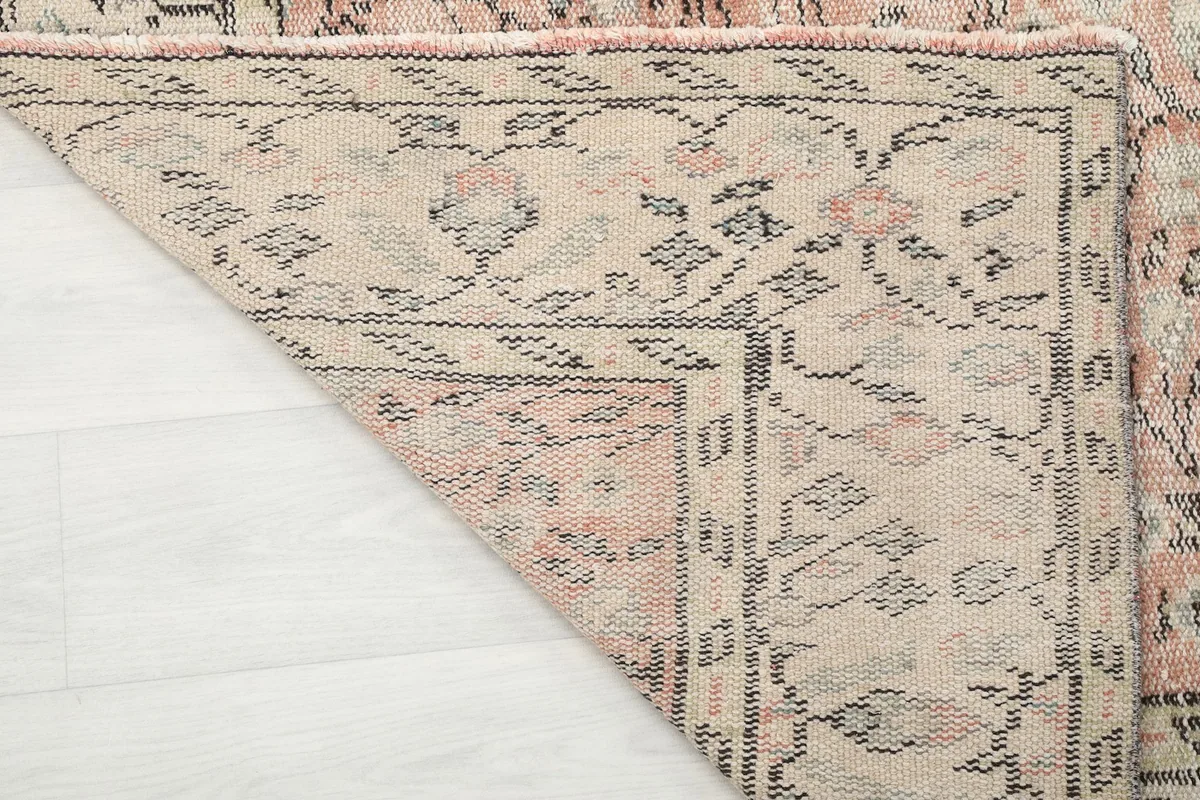 Underside corner of the hand-knotted rug, showing the cotton foundation