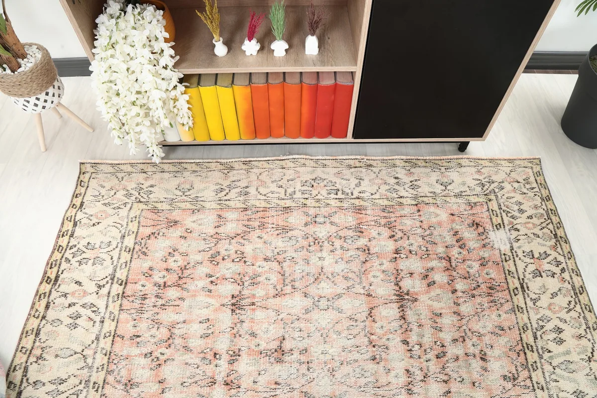 Overhead view focusing on the upper half of the rug, showing faded floral patterns