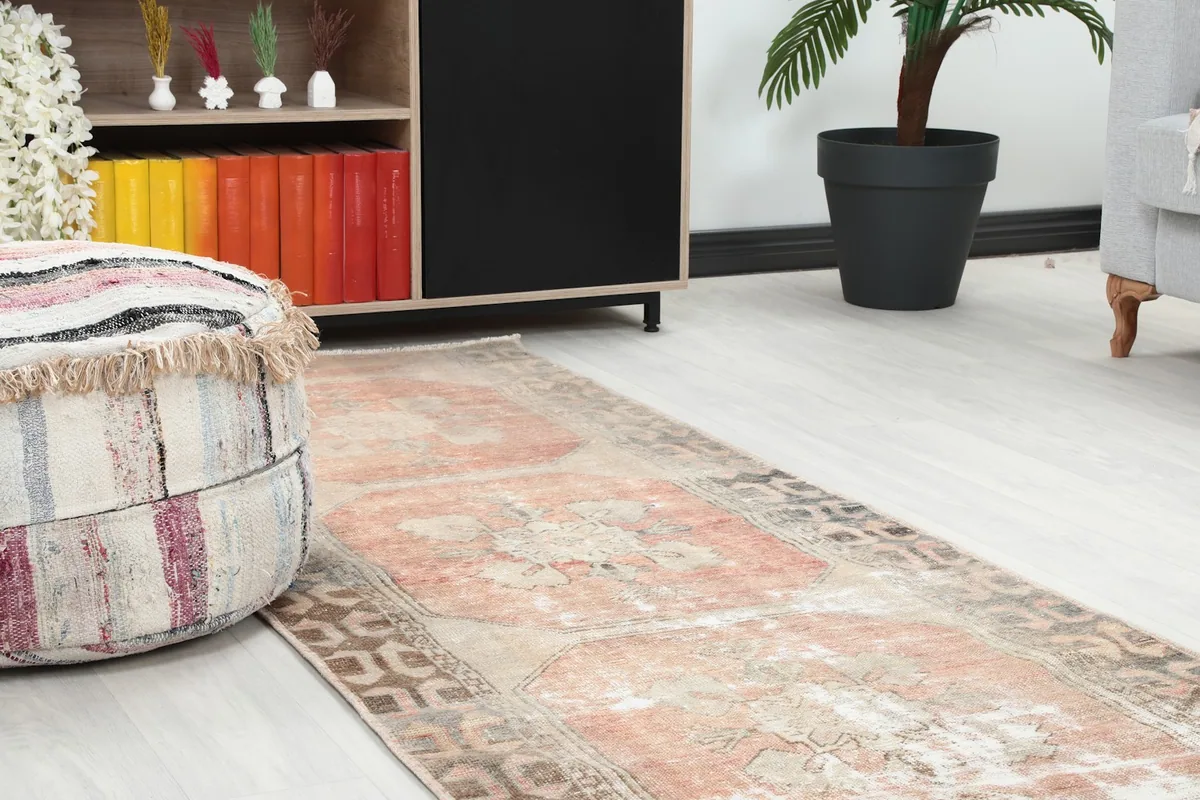 Close-up of the runner's texture and colors in a room setting, next to a striped pouf.