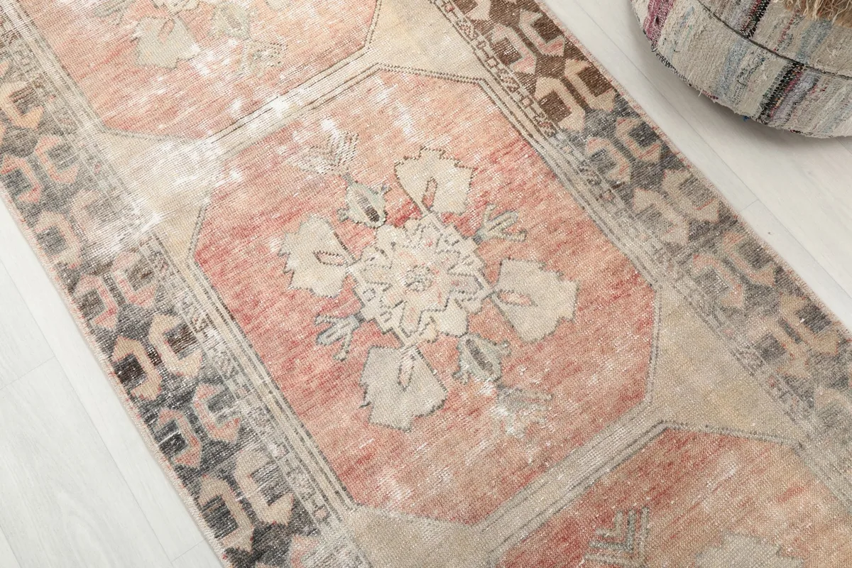 Close-up angle shot of a geometric medallion and surrounding border patterns on the runner.