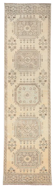 Full overhead view of the beige and brown geometric Anatolian runner rug on a white background