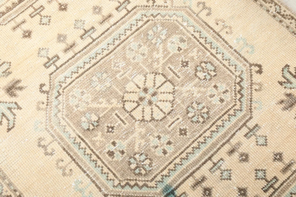 Close-up detail of a single geometric medallion, showing the intricate knotting and color variations including blue