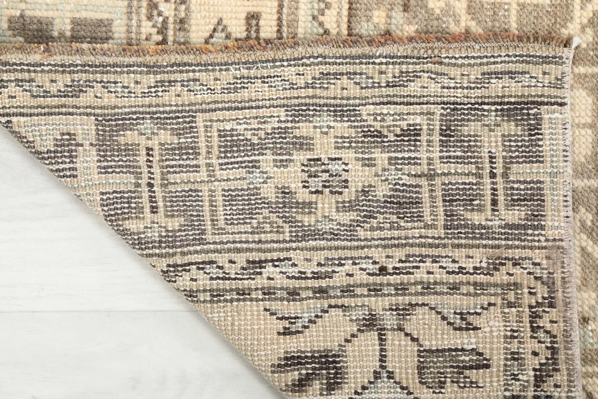 Underside of the rug, showing the tightly woven cotton foundation and the back of the hand-knotted pile