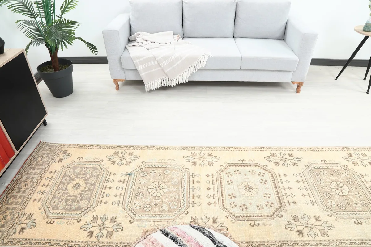 Overhead view showing the runner rug extending towards a light gray sofa, emphasizing its long shape