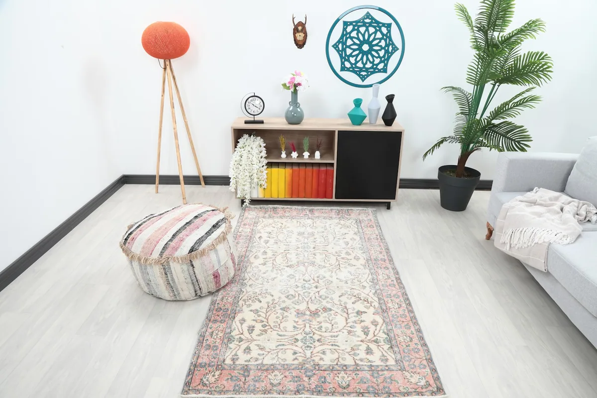The ivory and rose rug placed in a room setting, showing its scale relative to furniture.