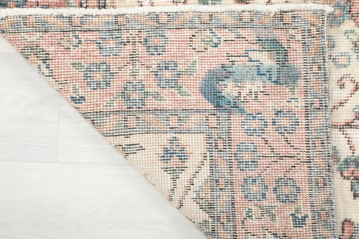 Corner detail of the rug, showing the interaction between the field and border patterns.